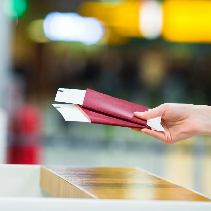 Havalimanında pasaport ve biniş kartı tutan el